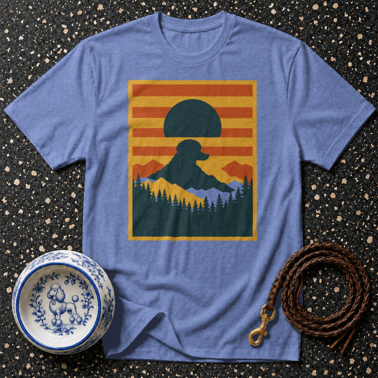 Blue t-shirt with graphic of dog silhouette on mountain with sun and trees.