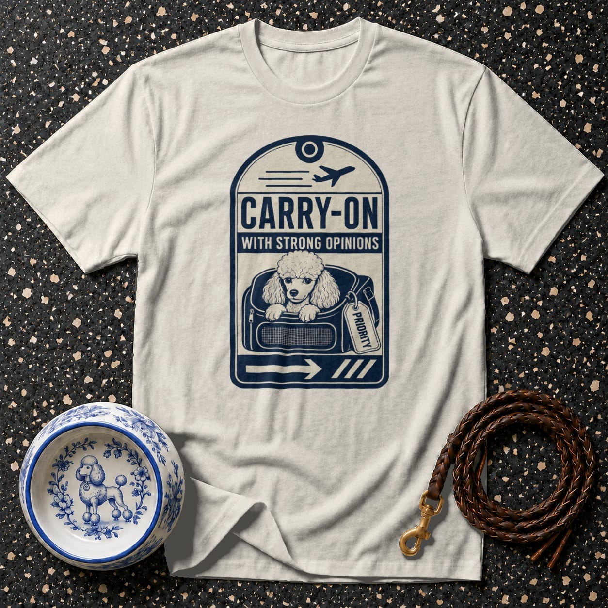 White t-shirt with a poodle in a carrier graphic that reads "CARRY-ON WITH STRONG OPINIONS".