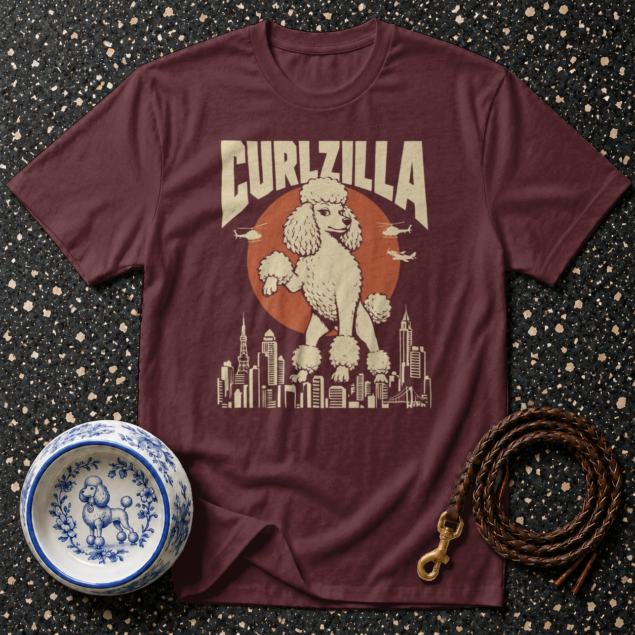 Maroon t-shirt featuring a cartoon poodle and the text "CURLZILLA" above a cityscape.