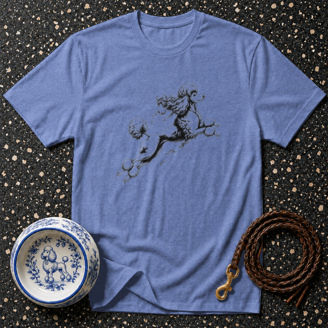 Blue t-shirt with poodle graphic, dog bowl, and leash on textured background.