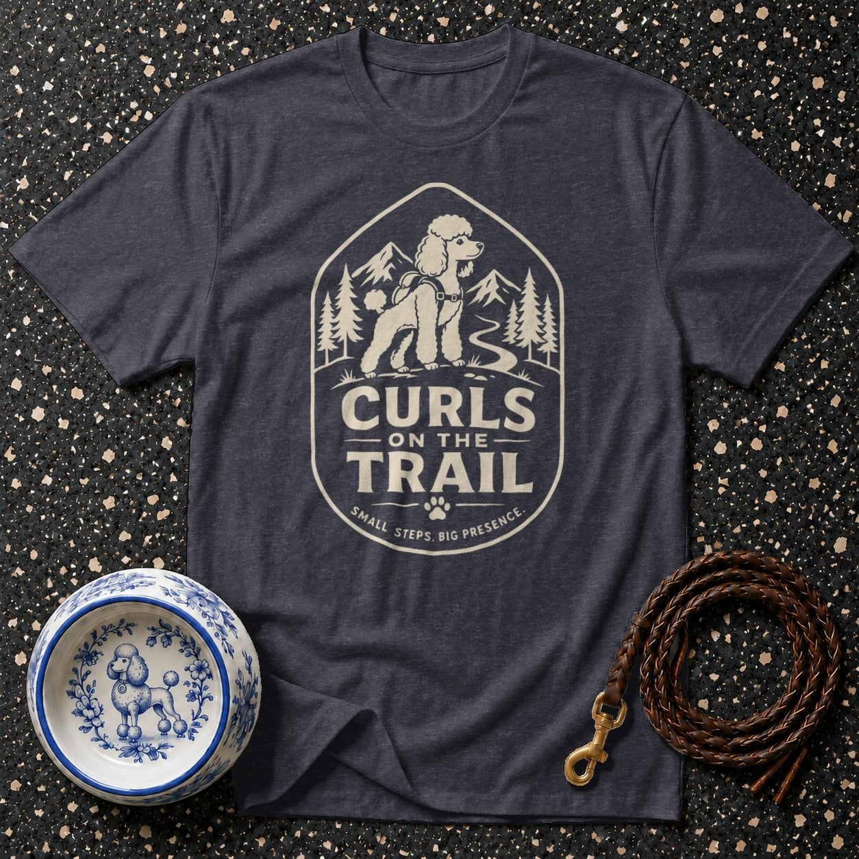 Dark t-shirt with a graphic of a poodle on a trail, reading "Curls On The Trail".