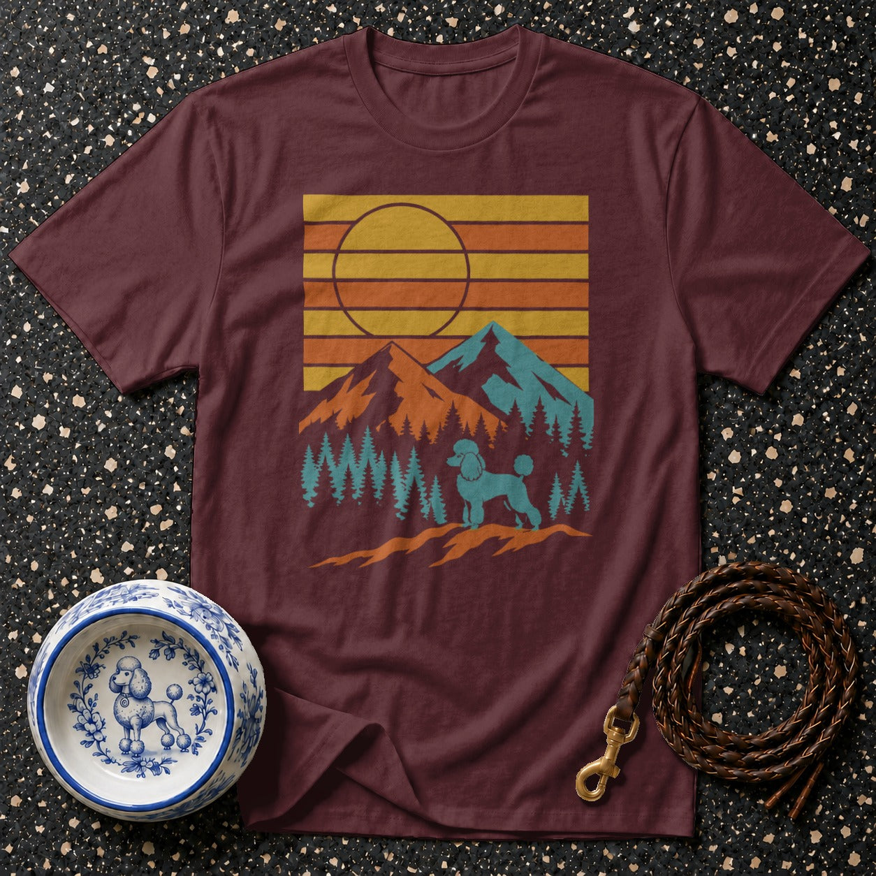 Maroon t-shirt with retro mountain sunset graphic featuring a poodle.
