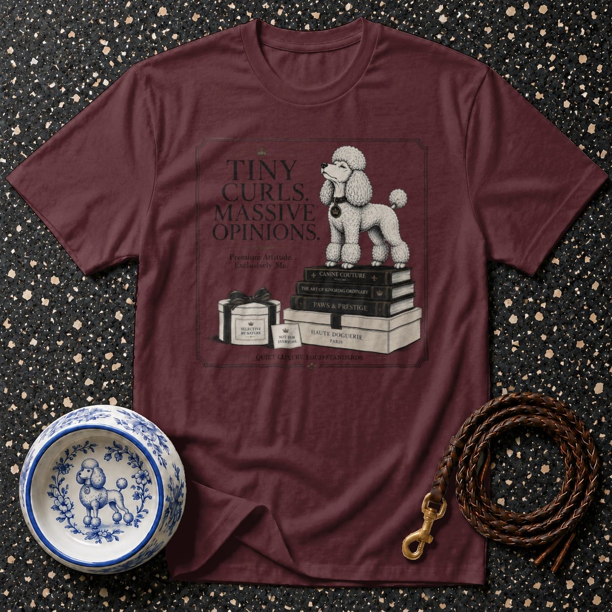 Maroon t-shirt with poodle graphic, books, and text: "Tiny Curls. Massive Opinions."