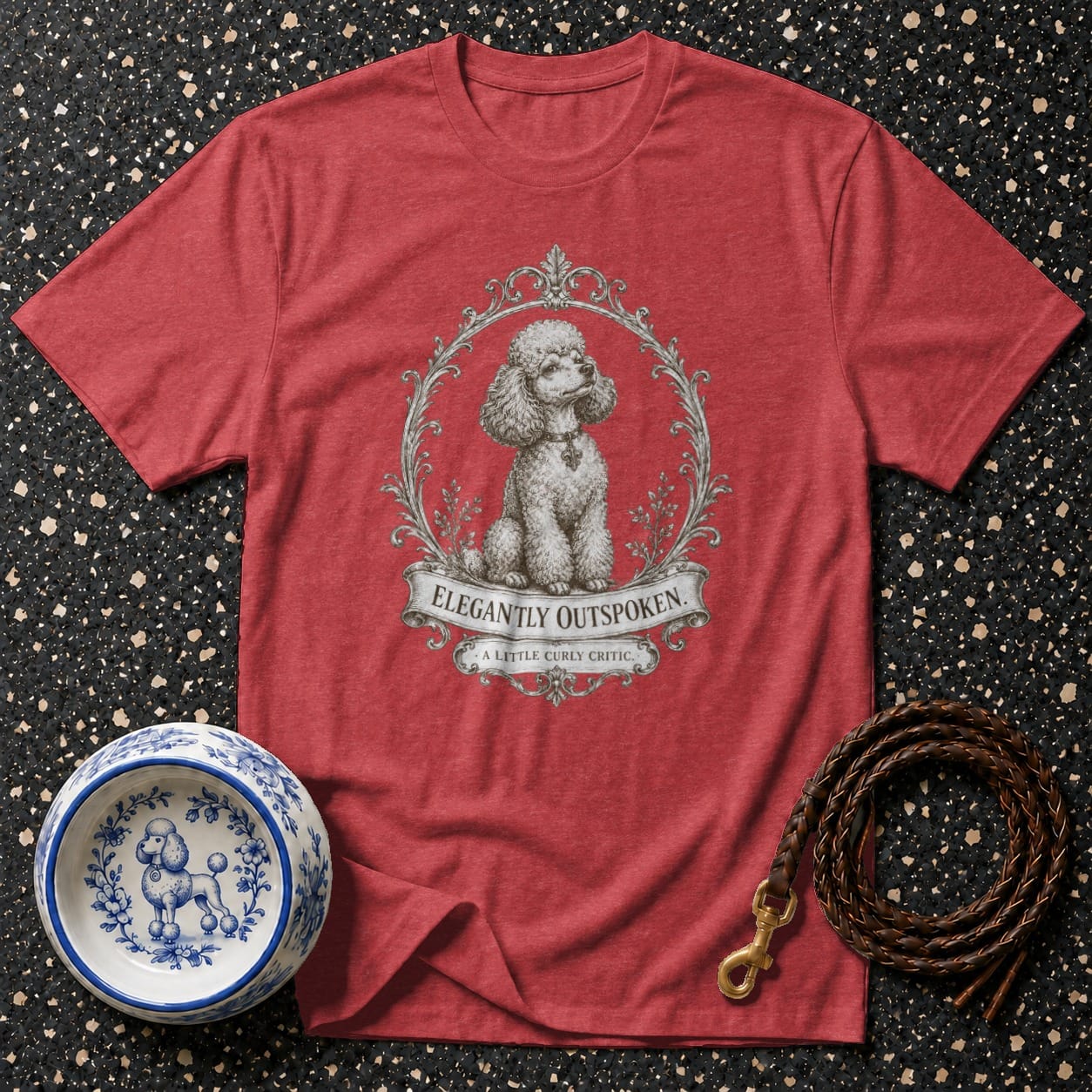 Red t-shirt with a poodle graphic and text "ELEGANTLY OUTSPOKEN. A LITTLE CURLY CRITIC."
