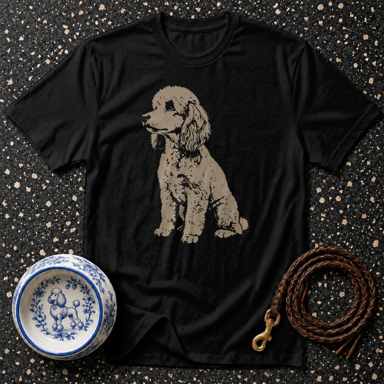Black t-shirt with a seated tan poodle graphic, a decorative dog bowl, and a leather leash.