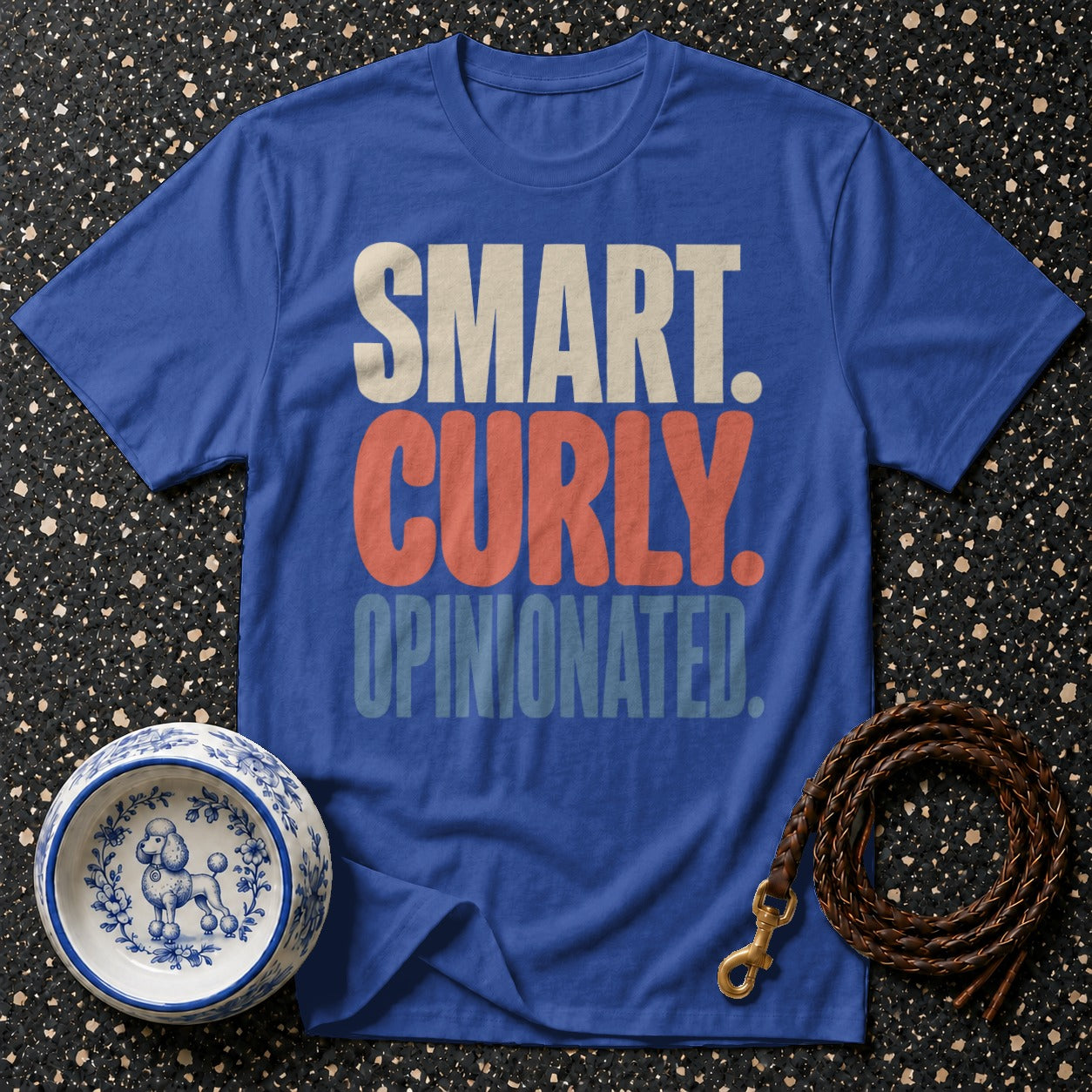 Blue t-shirt with text "SMART. CURLY. OPINIONATED." and poodle dog bowl.