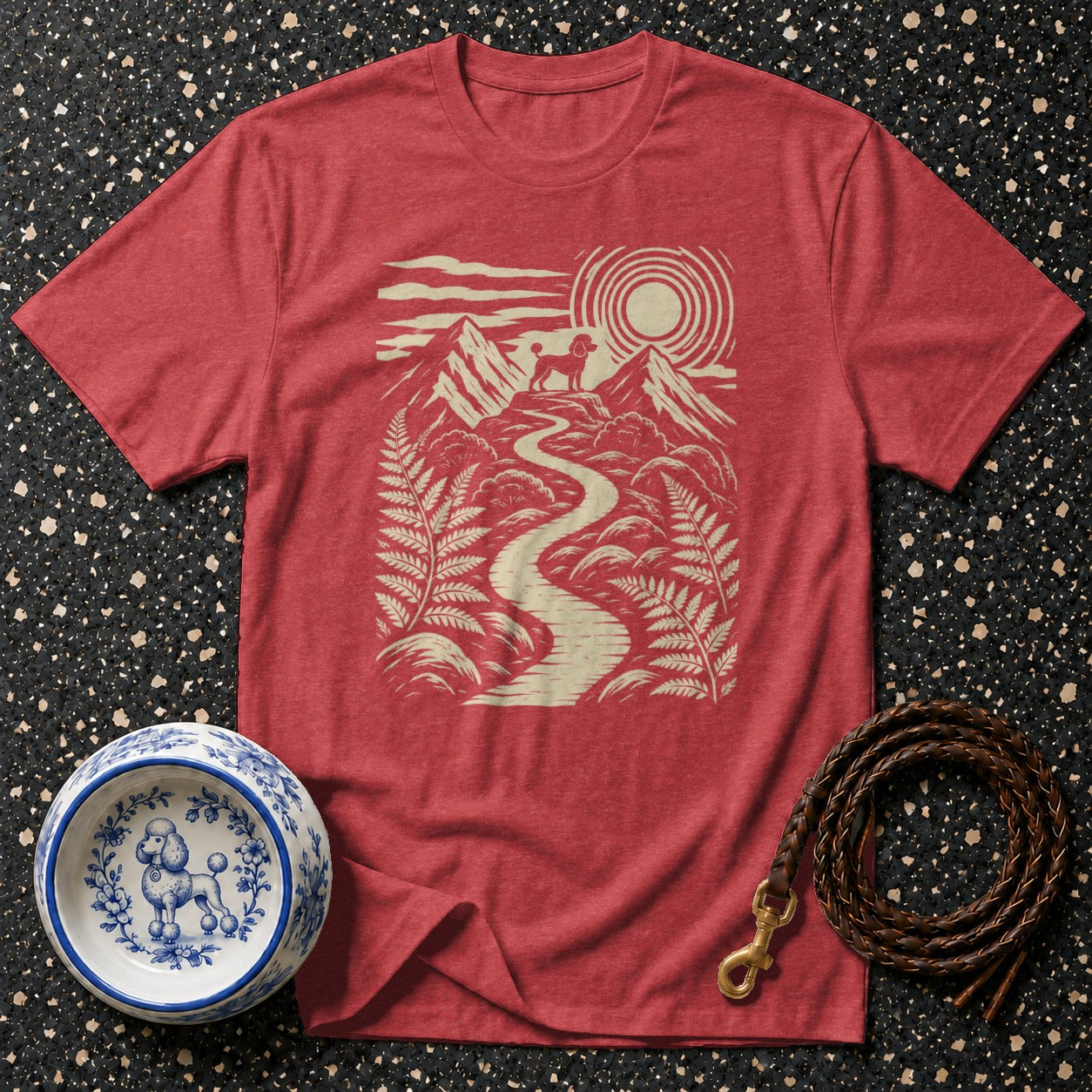 Red t-shirt with a cream graphic of a poodle on a mountain path.