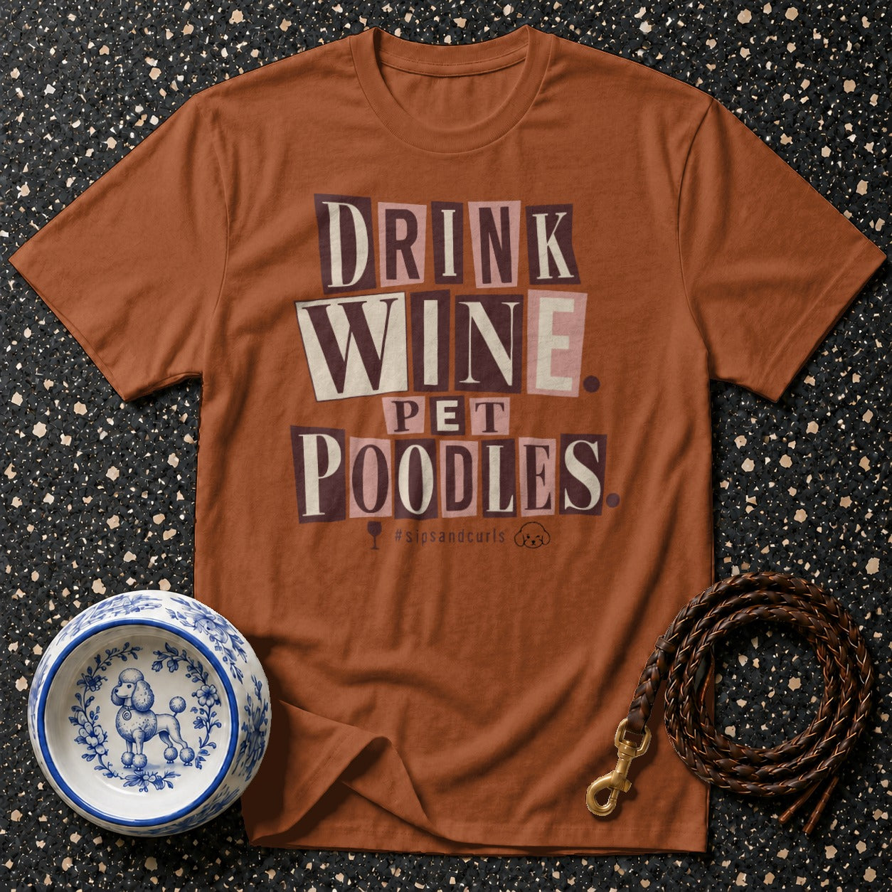 Brown t-shirt with "DRINK WINE PET POODLES" text and poodle-themed accessories.