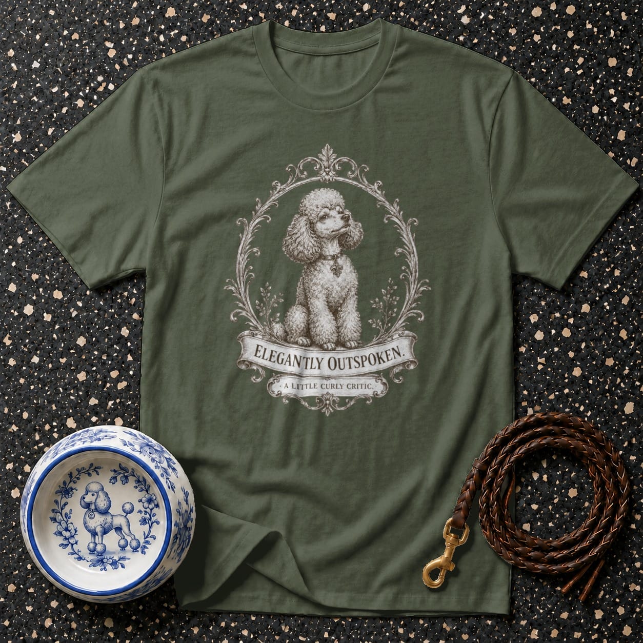 Green t-shirt with a framed poodle and text saying "ELEGANTLY OUTSPOKEN. A LITTLE CURLY CRITIC."