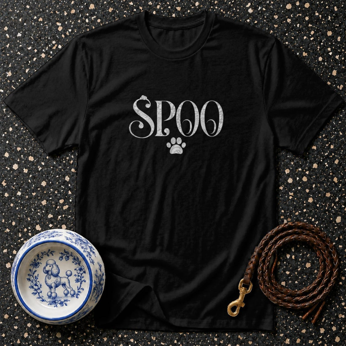 Black t-shirt with "SPOO" and a paw print, next to a dog bowl and leash.