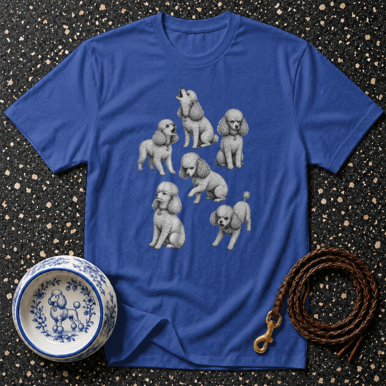 Blue t-shirt with a printed illustration of several white poodles in various poses.