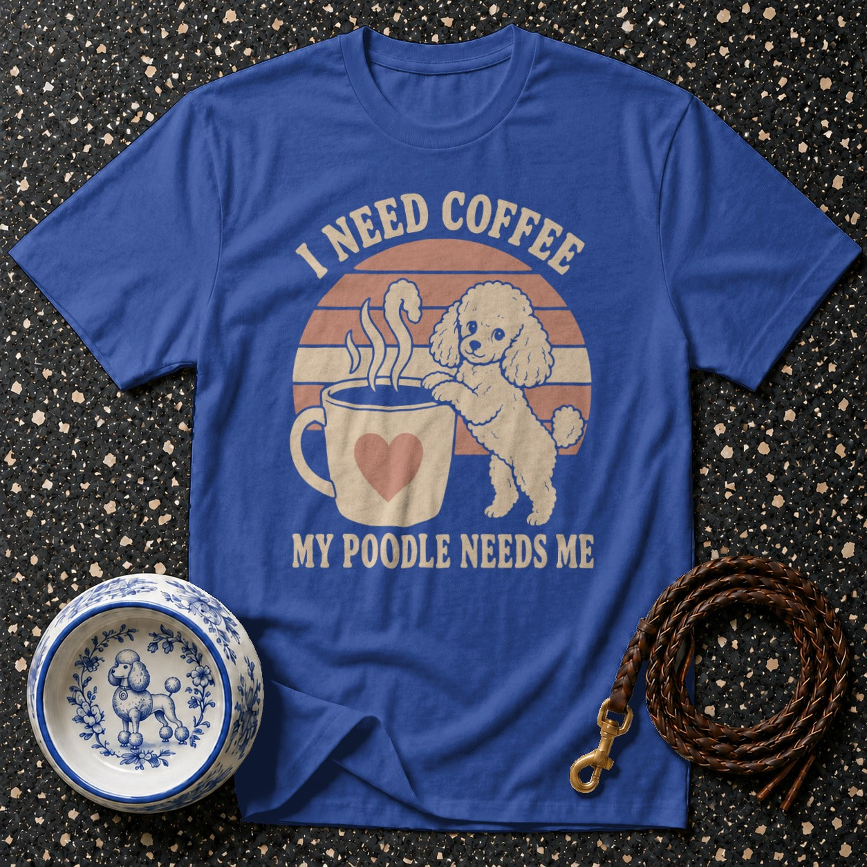 Blue t-shirt with a poodle and coffee cup graphic that says "I need coffee my poodle needs me."