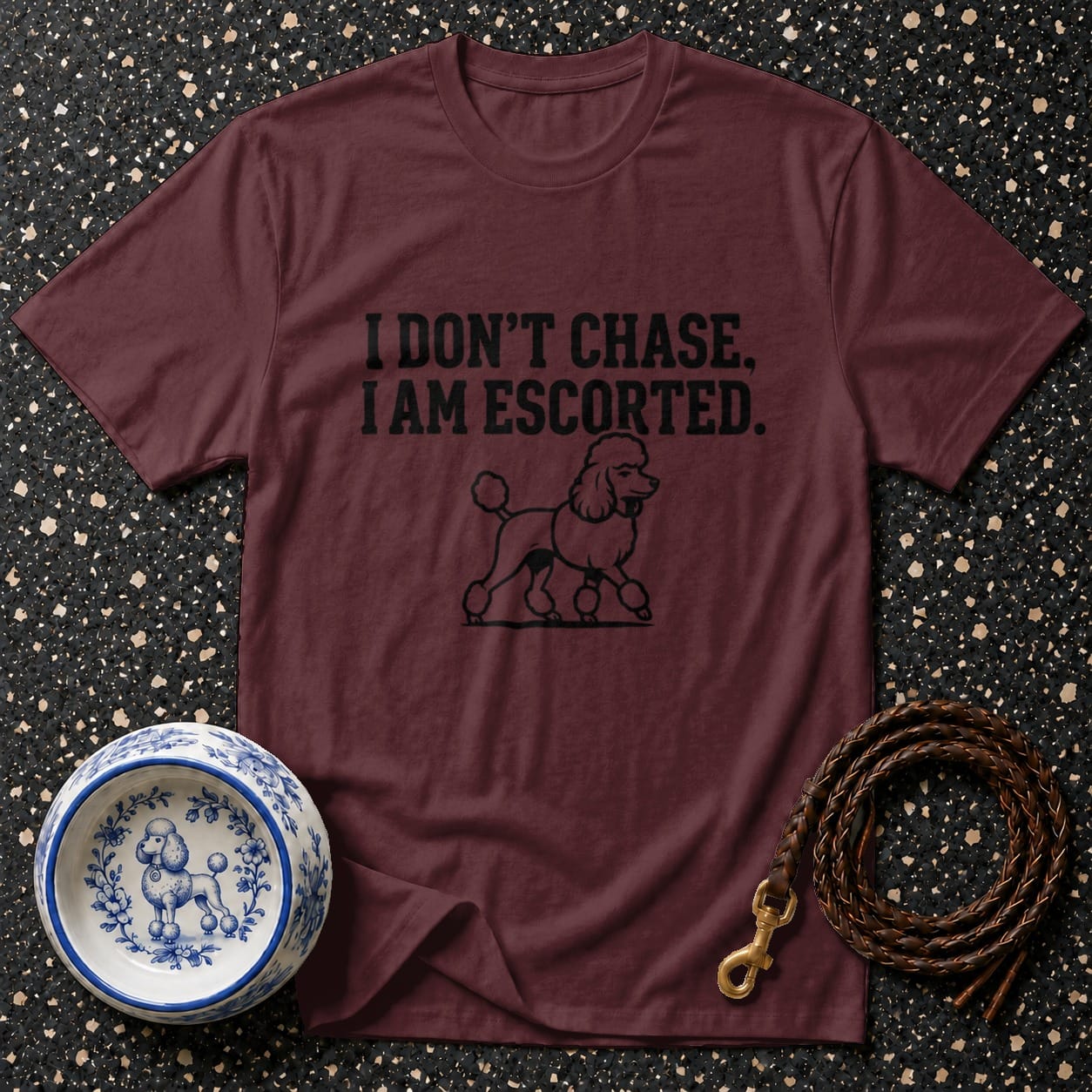 Maroon t-shirt with poodle graphic and text "I DON'T CHASE, I AM ESCORTED."
