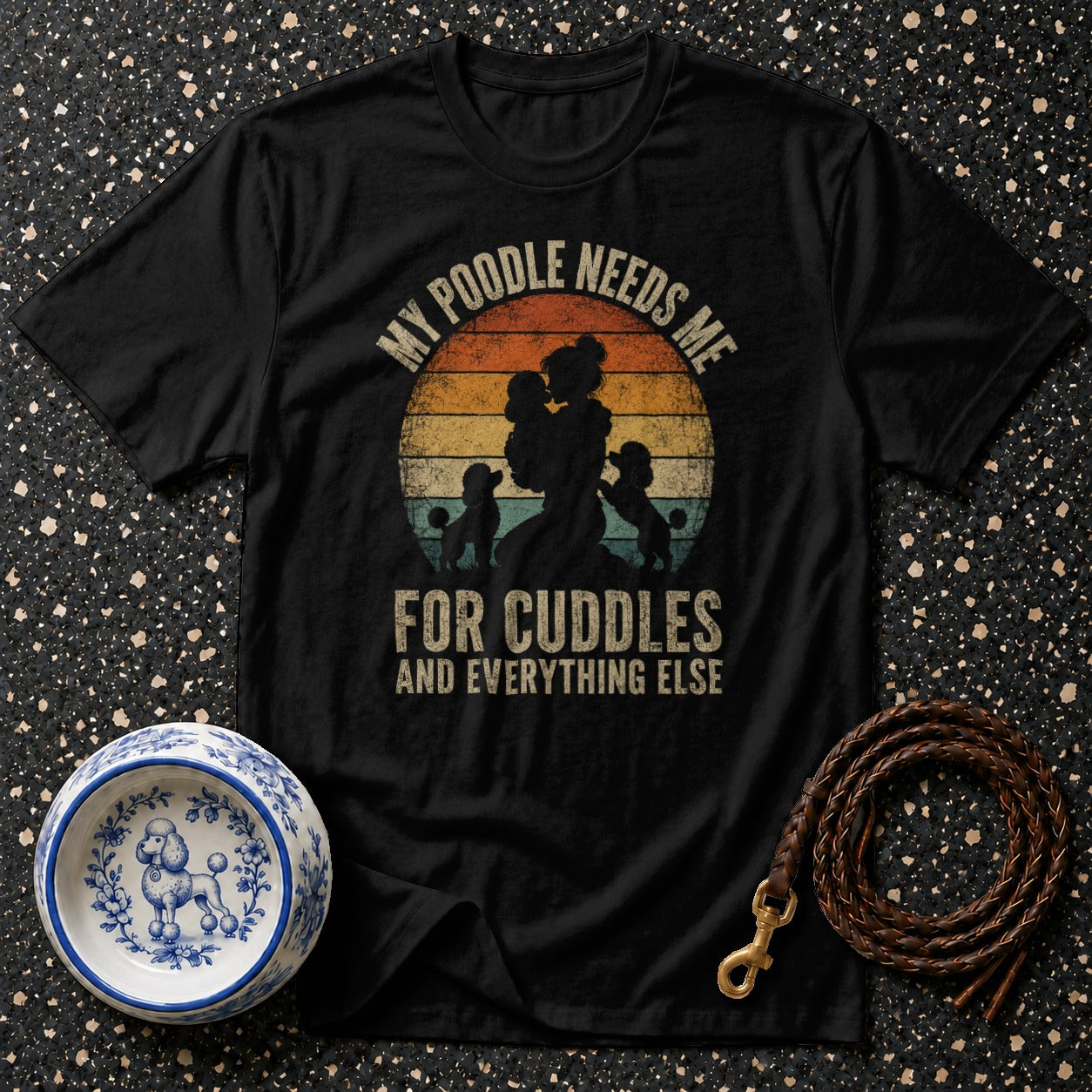Black t-shirt with vintage sunset design, poodles, and text "My poodle needs me for cuddles and everything else".