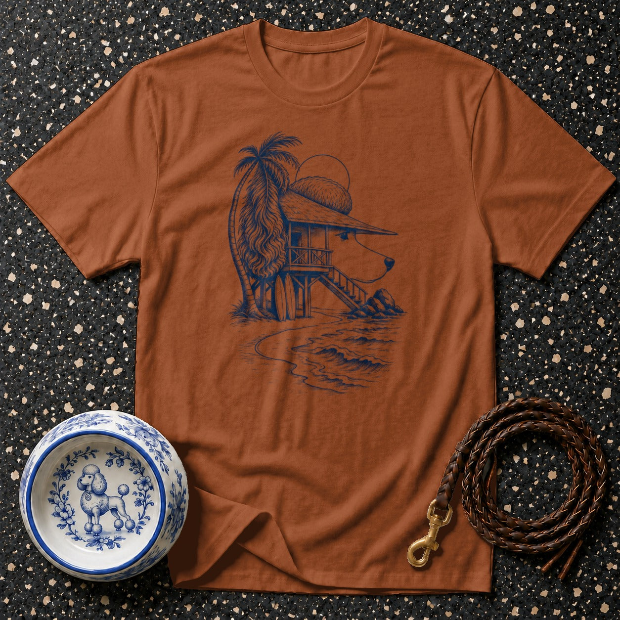 Brown t-shirt with a blue line drawing of a dog's head as a beach hut.