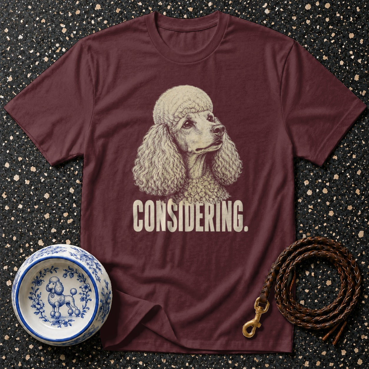 Maroon t-shirt with a poodle illustration and the word "CONSIDERING."