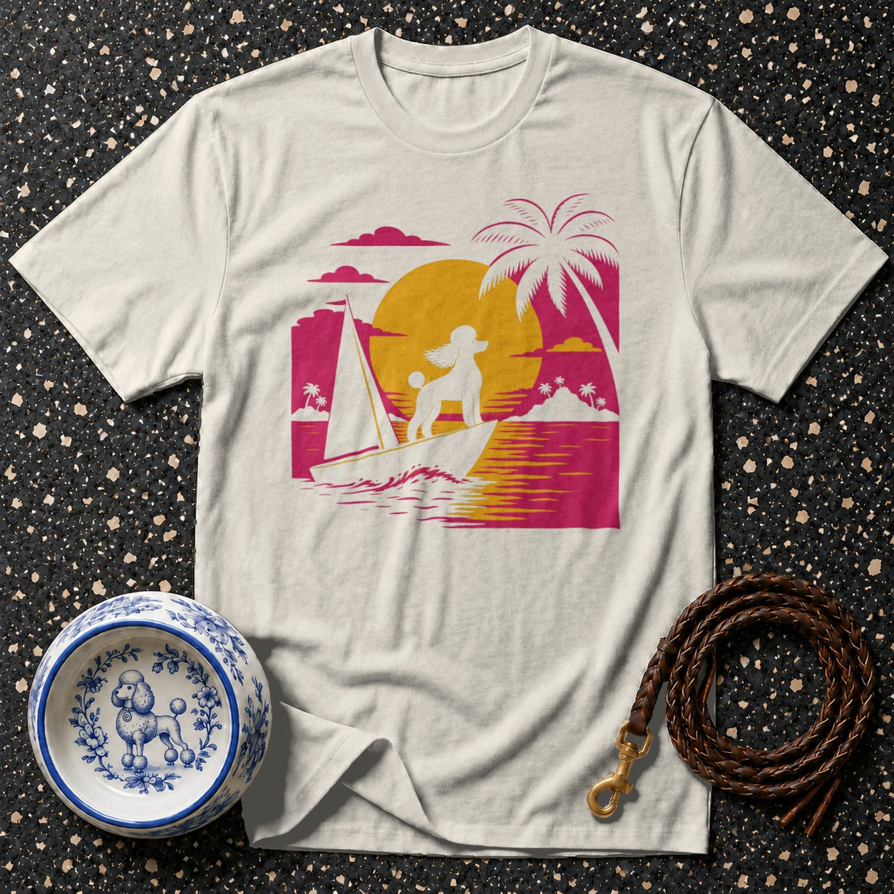 T-shirt with white poodle on sailboat against sunset and palm trees.