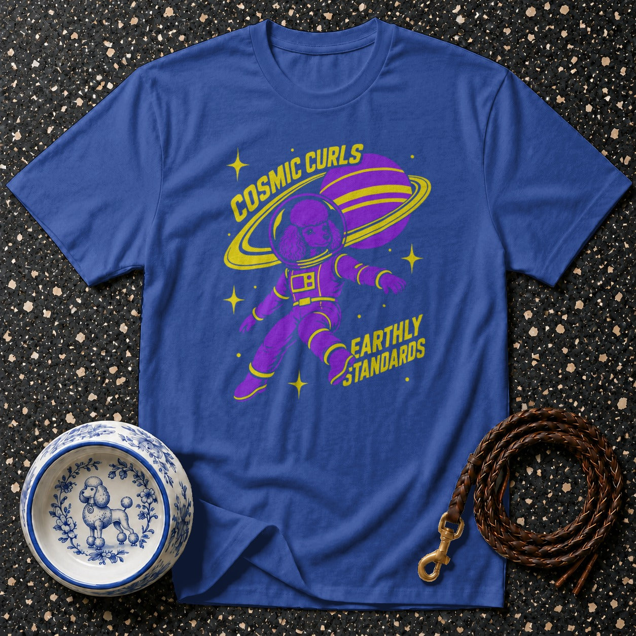 Blue t-shirt with purple poodle astronaut graphic and text "COSMIC CURLS EARTHLY STANDARDS".