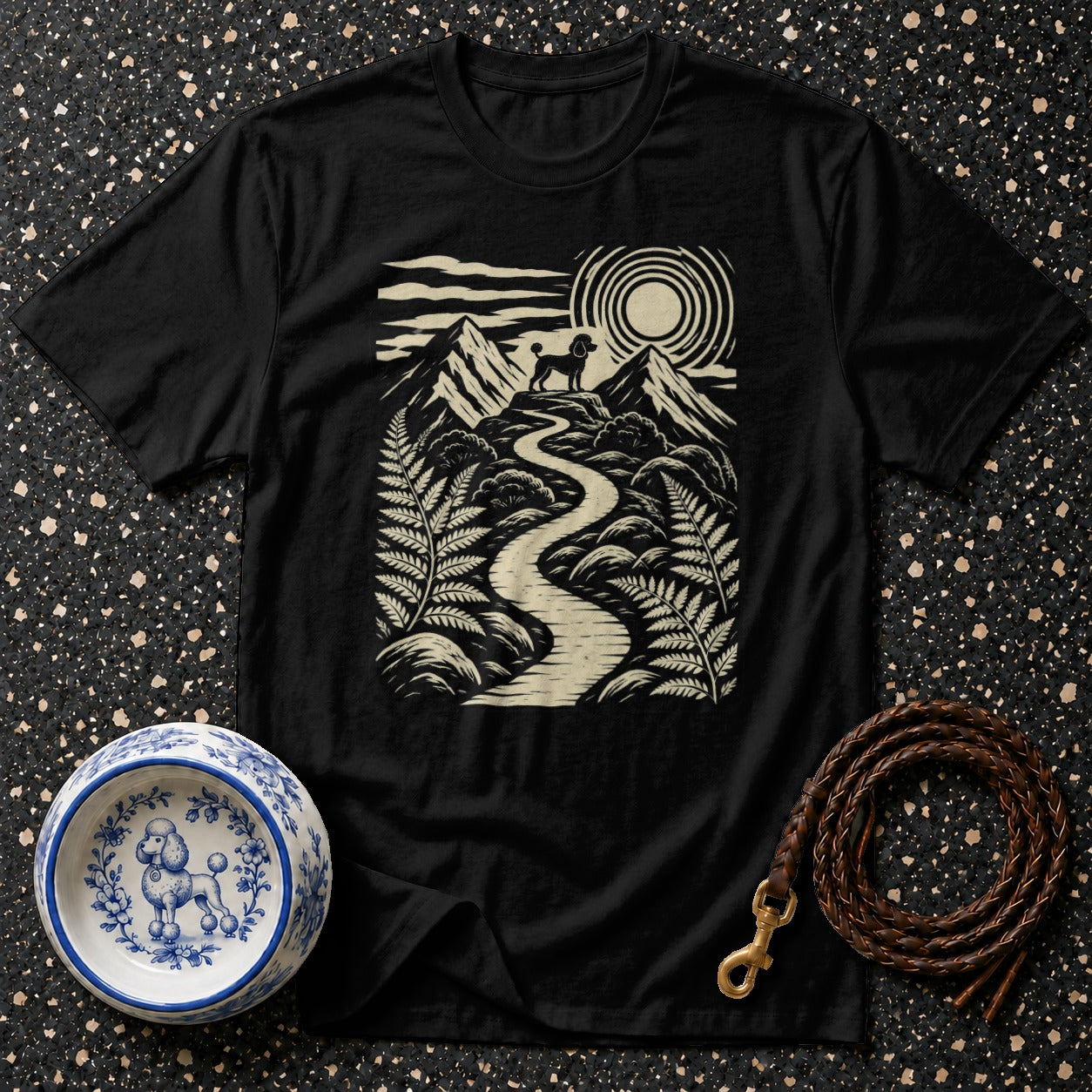 Black t-shirt with a scenic mountain landscape featuring a poodle on a winding path.