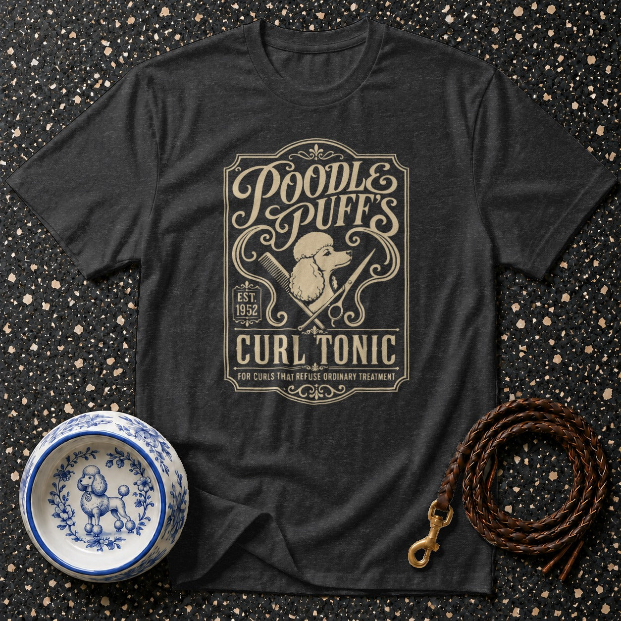 Dark grey t-shirt with "Poodle Puff's Curl Tonic Est. 1952" graphic.