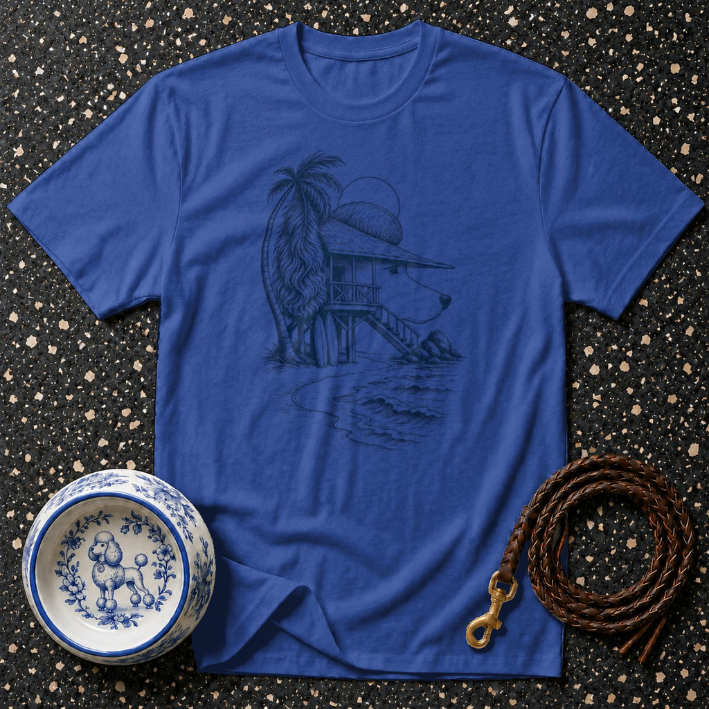 Blue t-shirt with sketch of dog house on beach, palm tree, and surfboard.