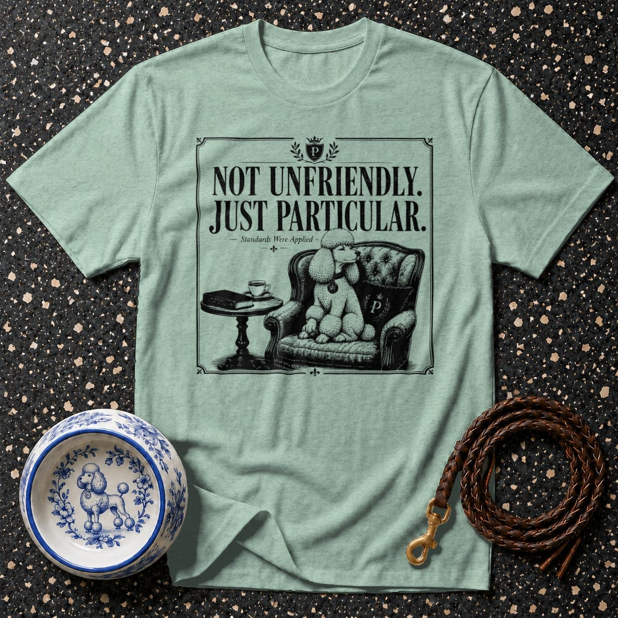 T-shirt graphic: poodle in armchair with text "NOT UNFRIENDLY. JUST PARTICULAR."
