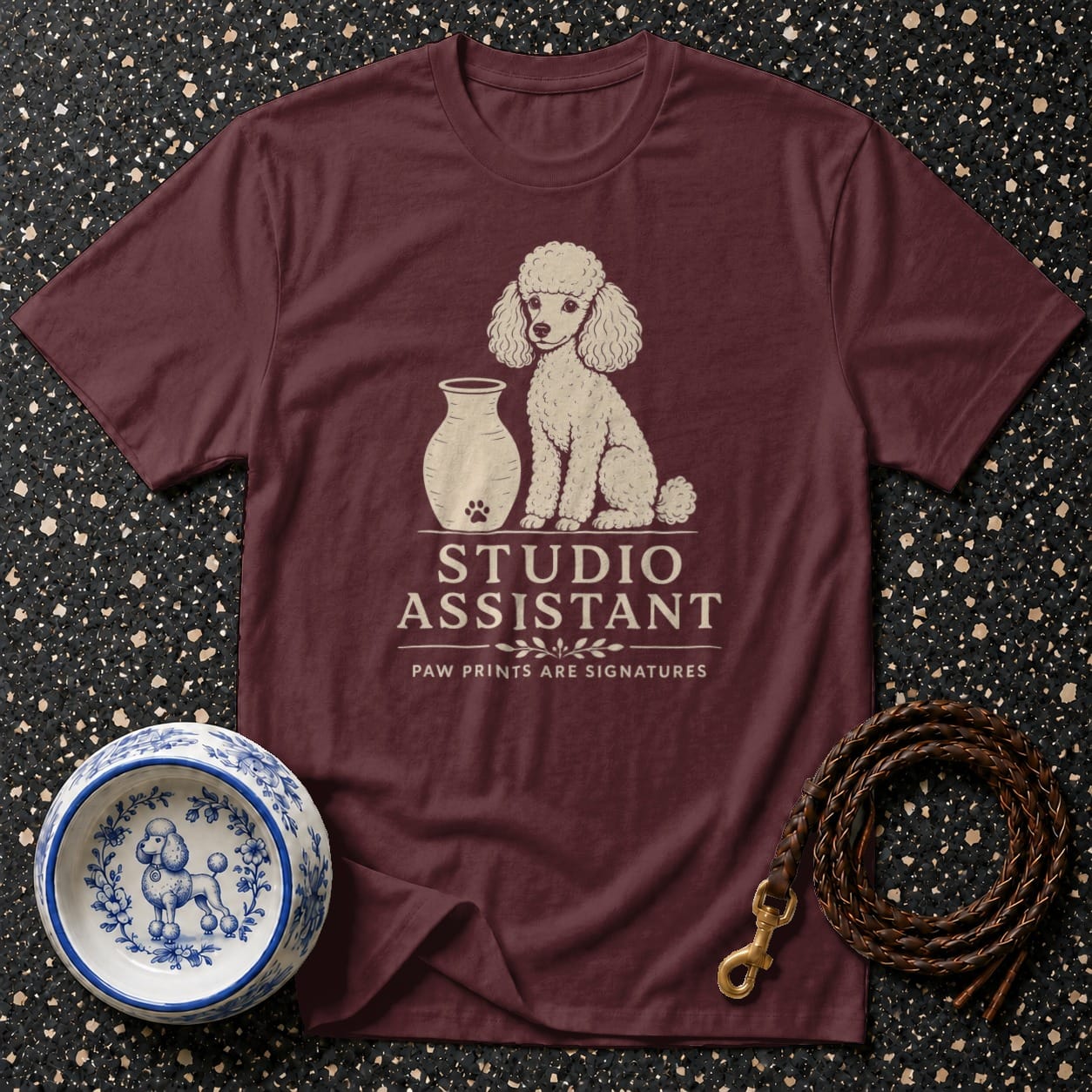 Maroon t-shirt with a poodle illustration and "Studio Assistant Paw Prints Are Signatures" text.