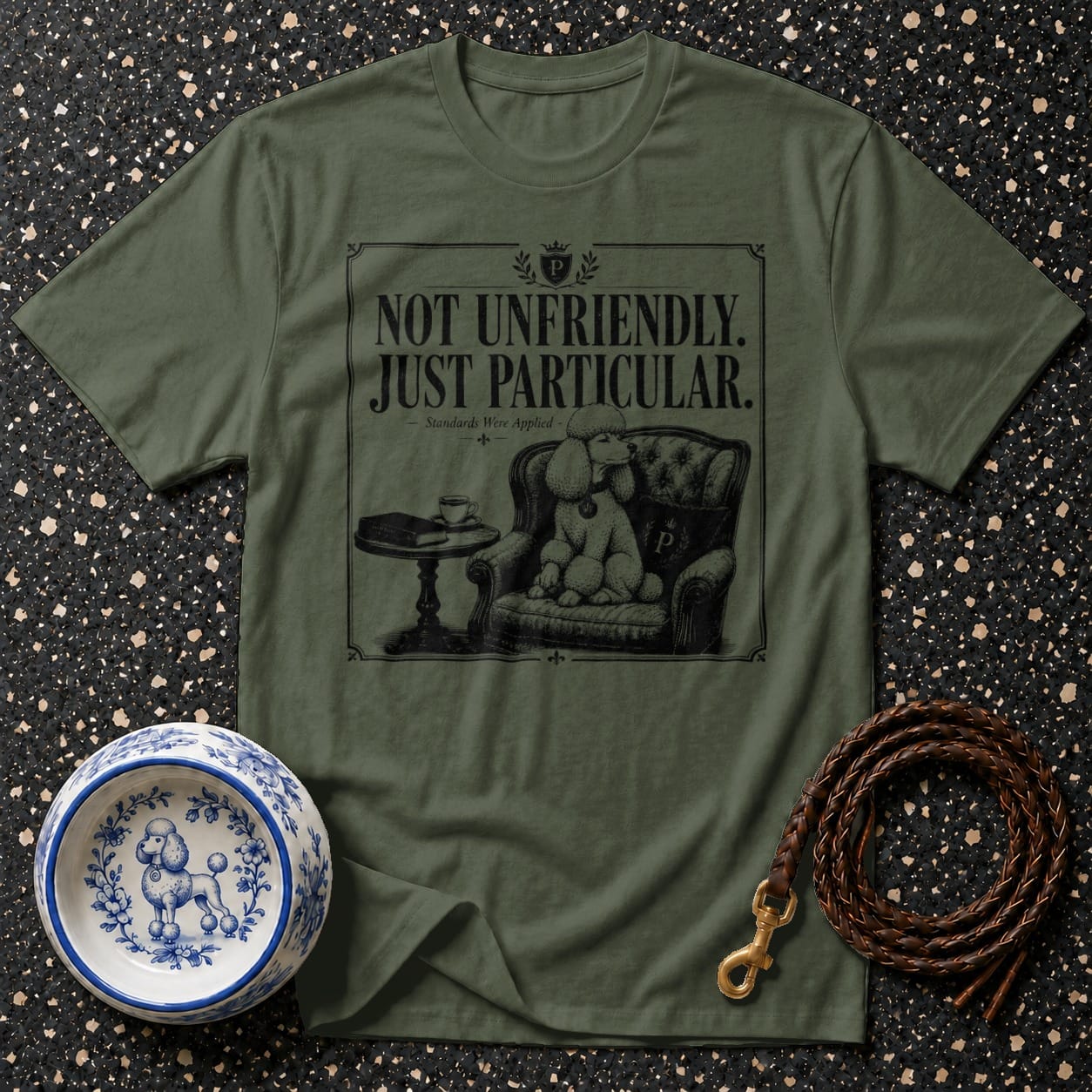 Green t-shirt with "NOT UNFRIENDLY. JUST PARTICULAR." and poodle on armchair graphic.