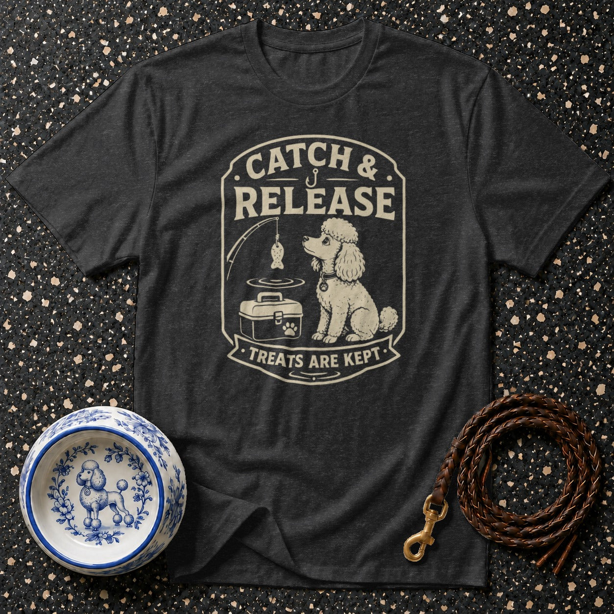 Dark gray t-shirt with cream graphic of a poodle fishing, text "Catch & Release".