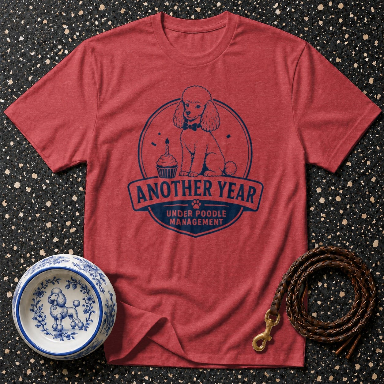 Red t-shirt with a poodle, cupcake, and text "Another Year Under Poodle Management".