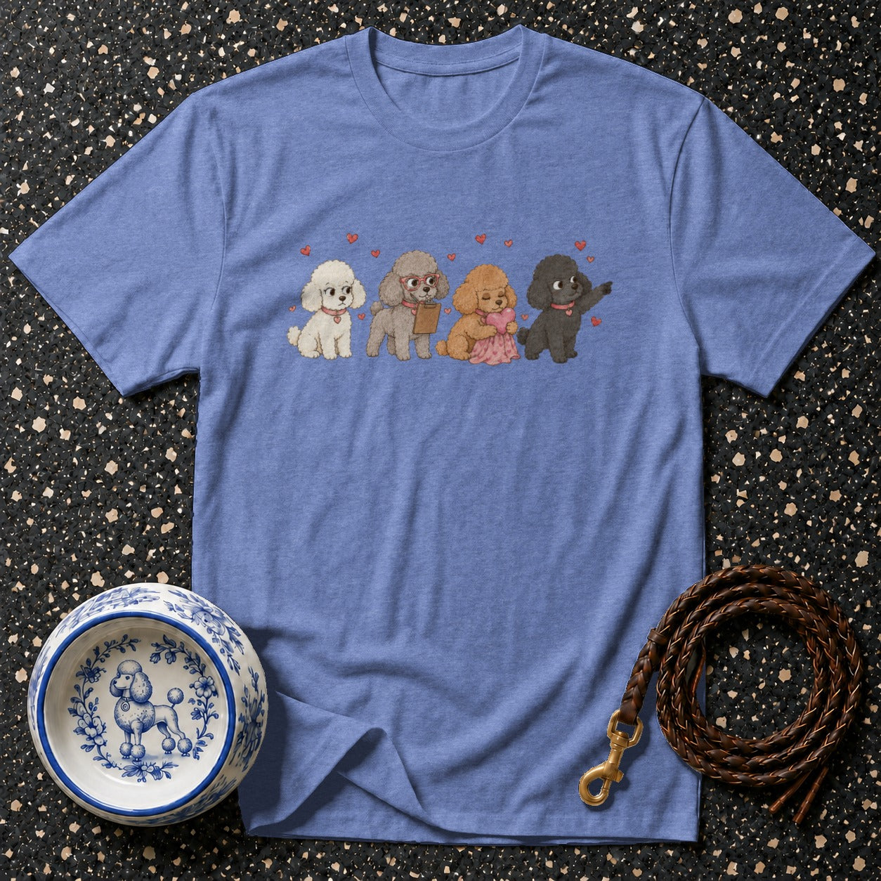 A blue t-shirt with a printed graphic of four poodles wearing collars and hearts.