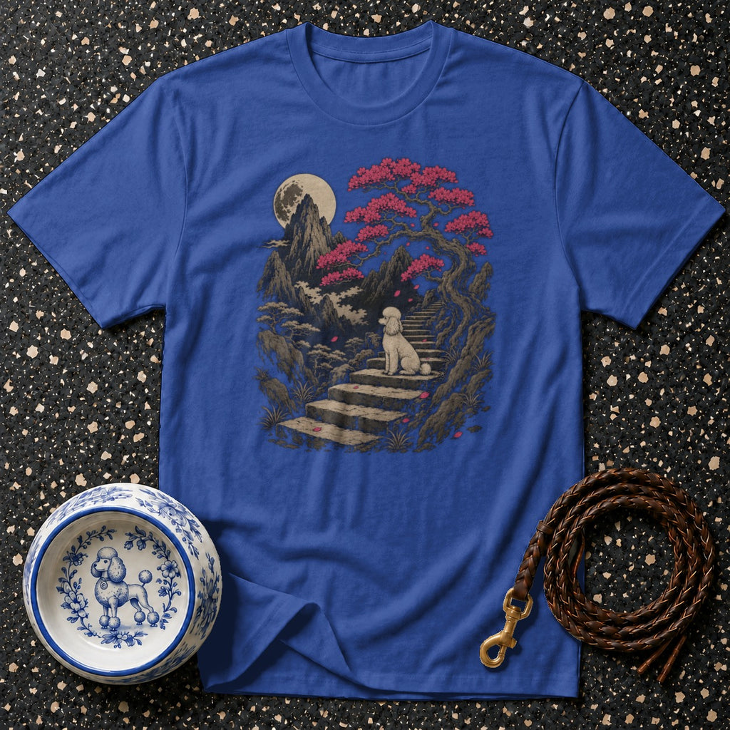 Blue t-shirt with a scenic print of a poodle sitting on steps under a full moon and blooming tree.