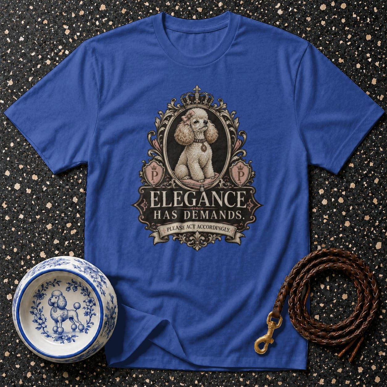 Blue t-shirt with a poodle and crown graphic. Text reads "Elegance Has Demands."