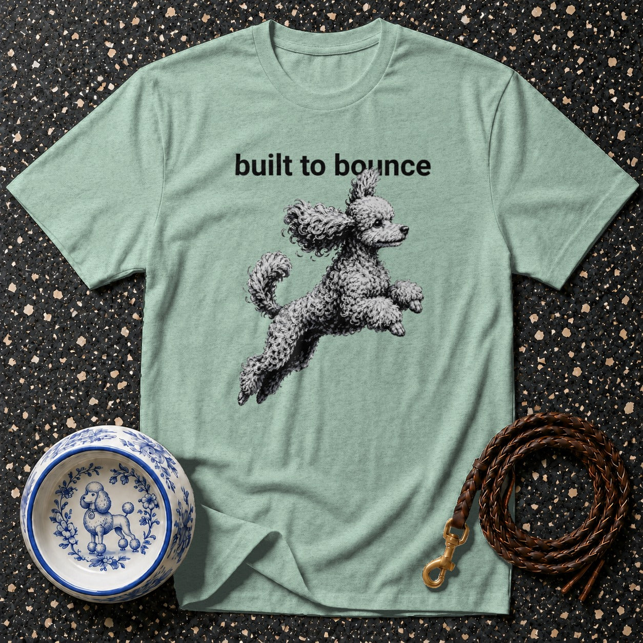 Light green t-shirt with black text "built to bounce" and a poodle graphic.