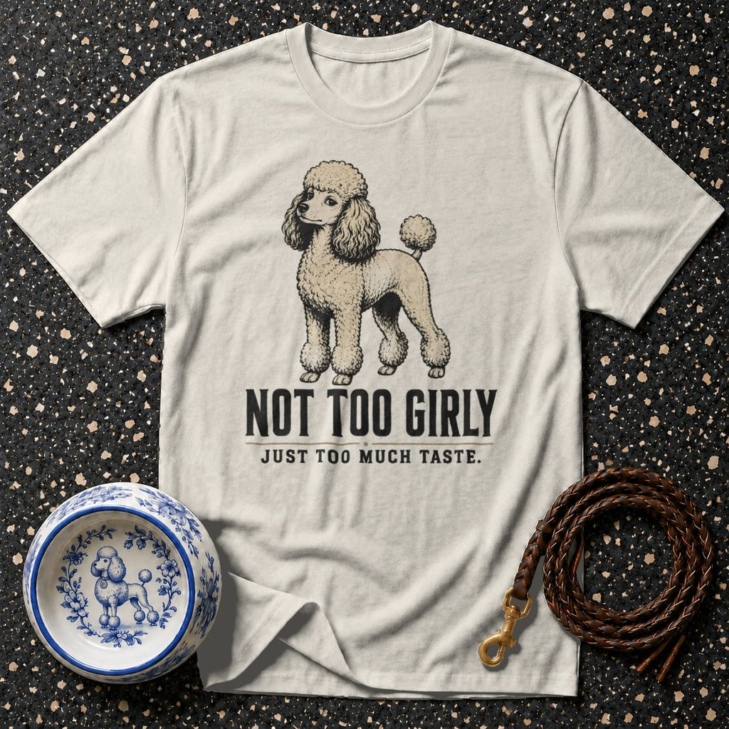 Cream t-shirt with poodle graphic and text "NOT TOO GIRLY JUST TOO MUCH TASTE."
