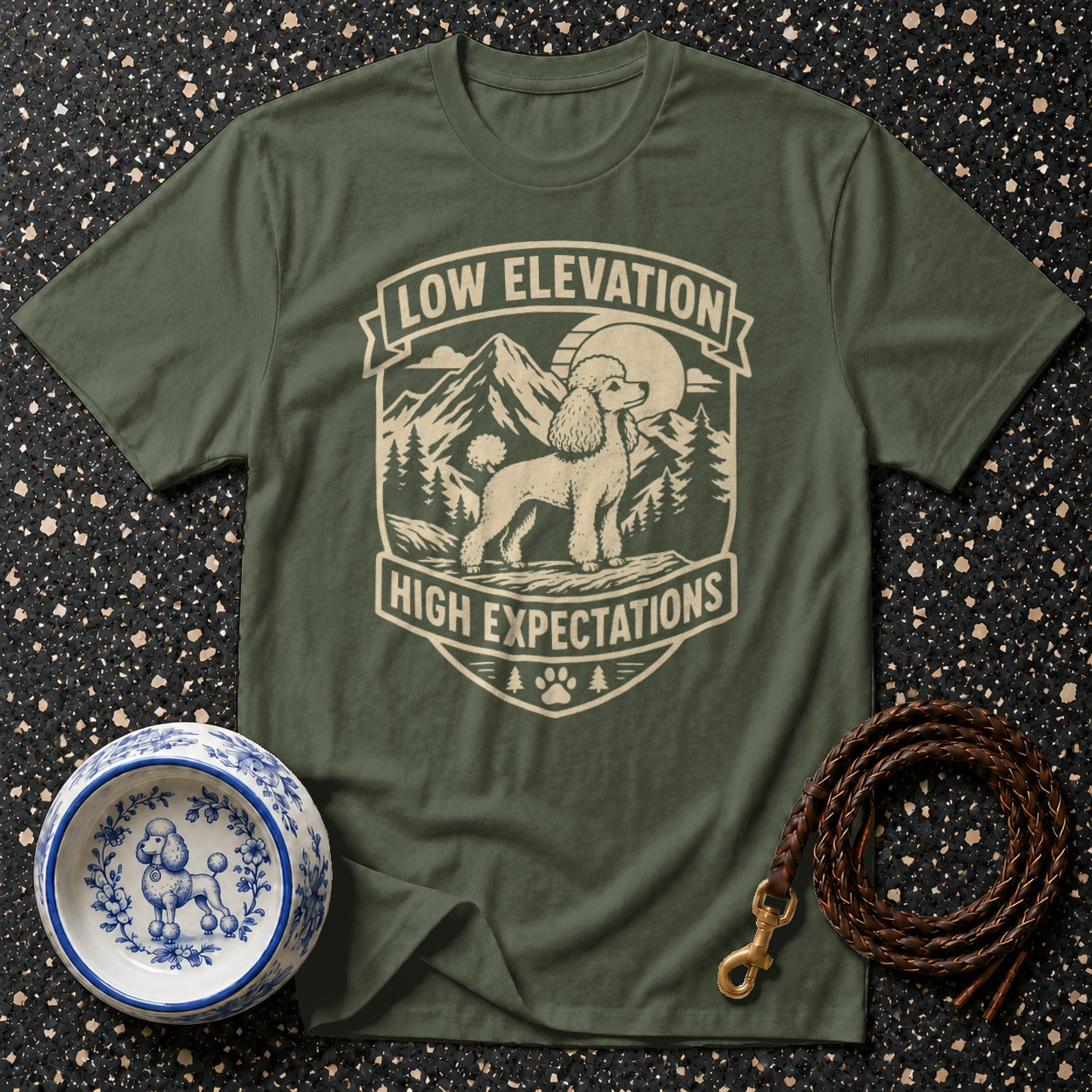 Green t-shirt with a poodle and mountains design reading "Low Elevation, High Expectations".