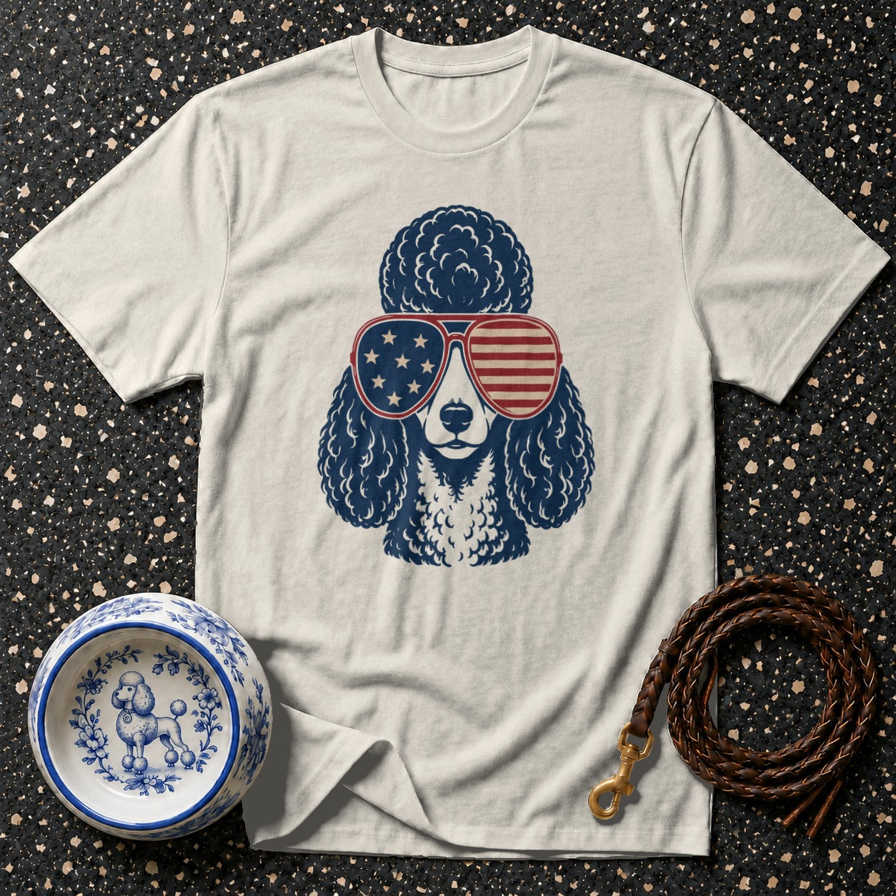 White t-shirt with blue poodle wearing American flag sunglasses.