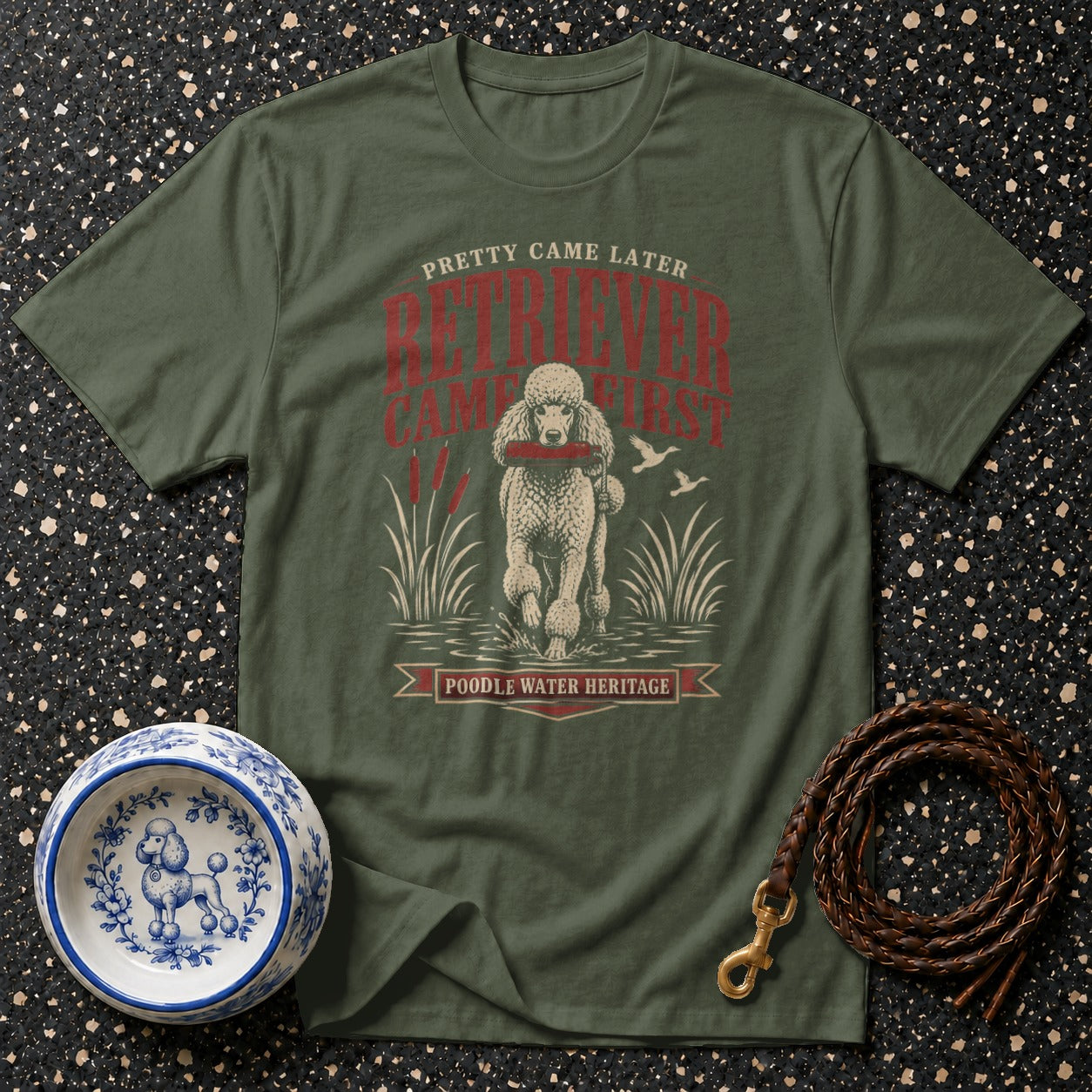 Olive green t-shirt with a poodle retrieving a stick, text reads "POODLE WATER HERITAGE."