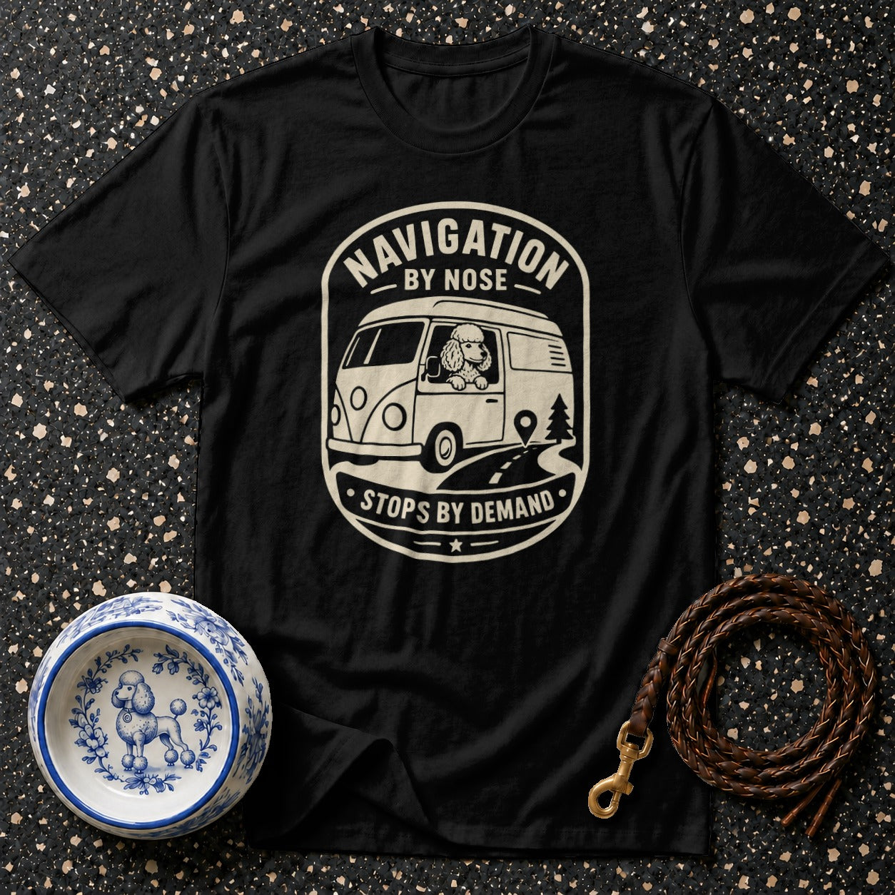 Black t-shirt with "Navigation by Nose Stops by Demand" graphic of a poodle driving a van.