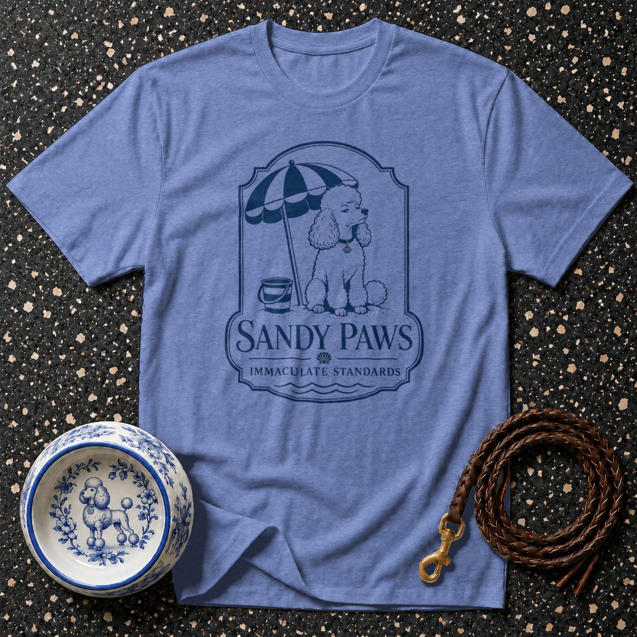 Blue t-shirt with a poodle under an umbrella and the text "SANDY PAWS".