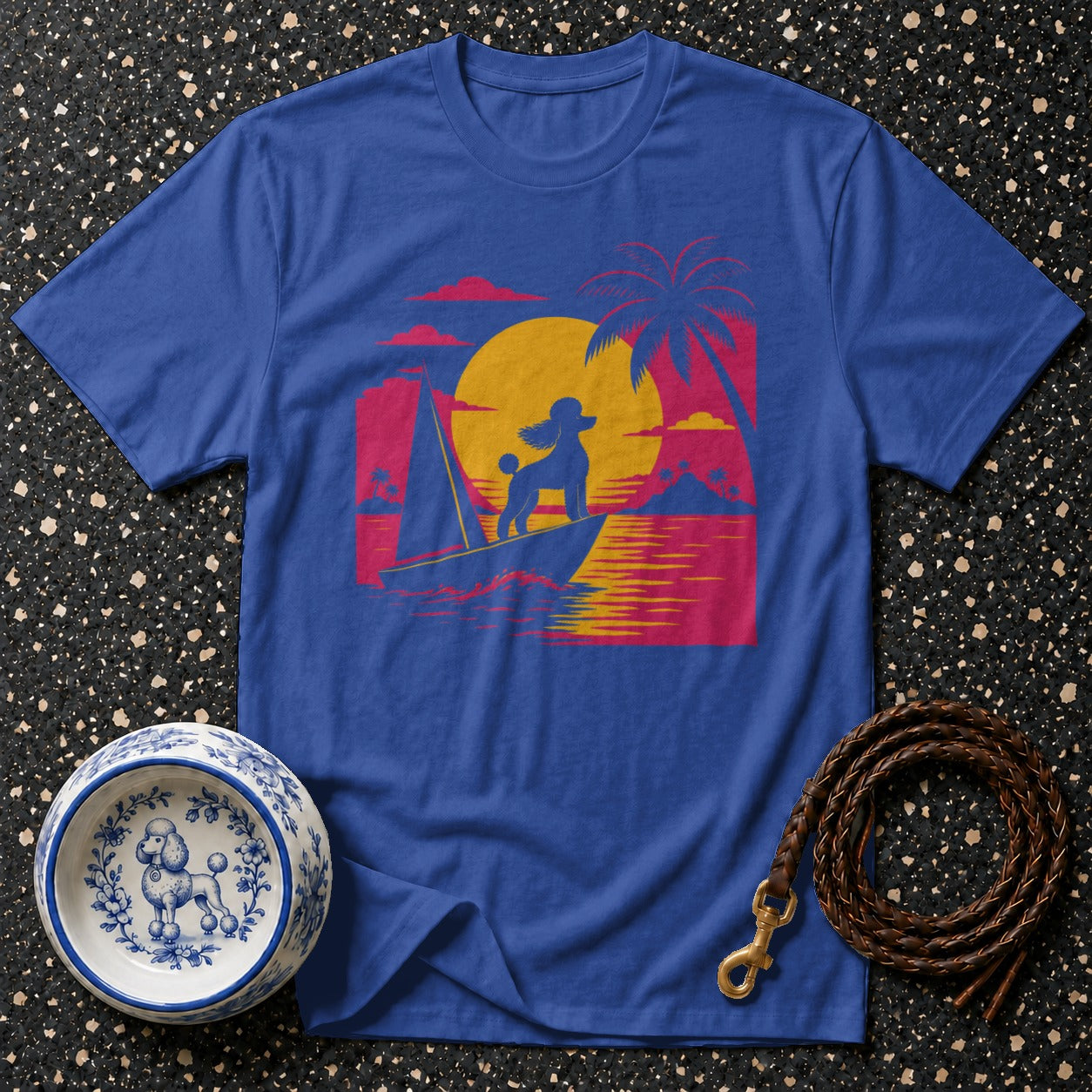 Blue t-shirt with poodle on sailboat graphic at sunset.