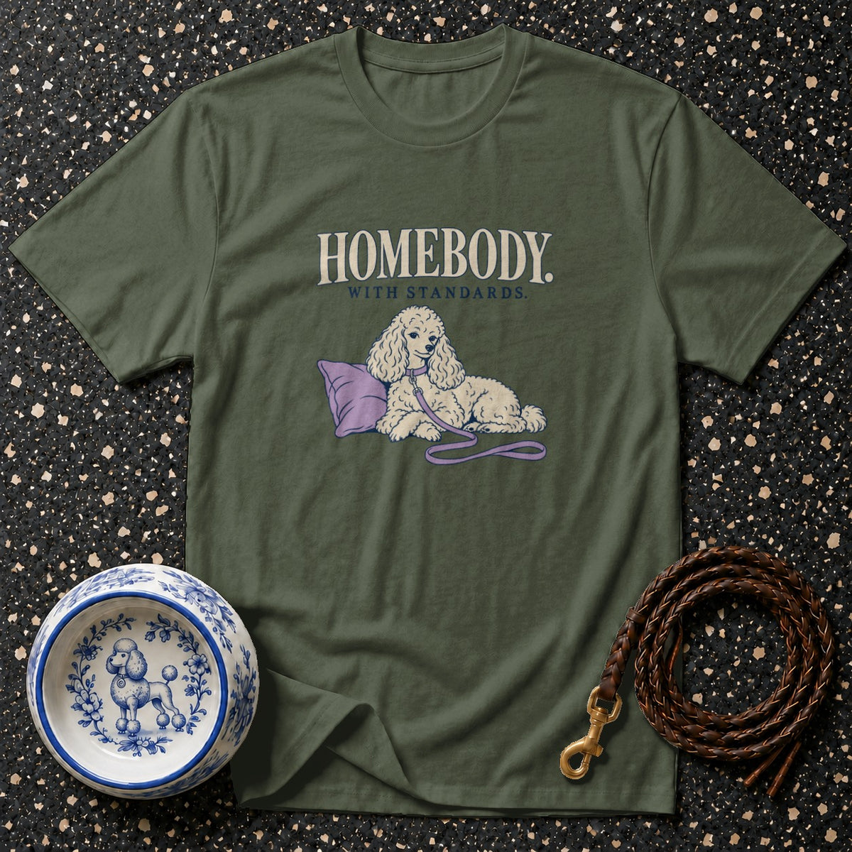 Green t-shirt with "HOMEBODY WITH STANDARDS" text and a poodle on a pillow.
