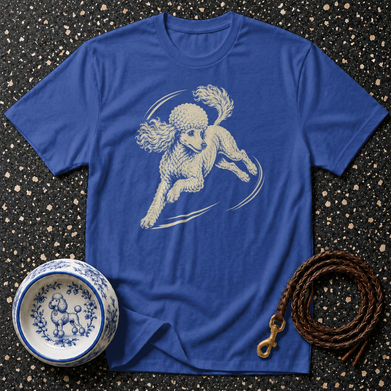 Blue t-shirt with cream poodle illustration, dog bowl, and leather leash.