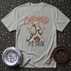 Grey t-shirt with a poodle and coffee cup graphic saying "Caffeinated Still Judging".