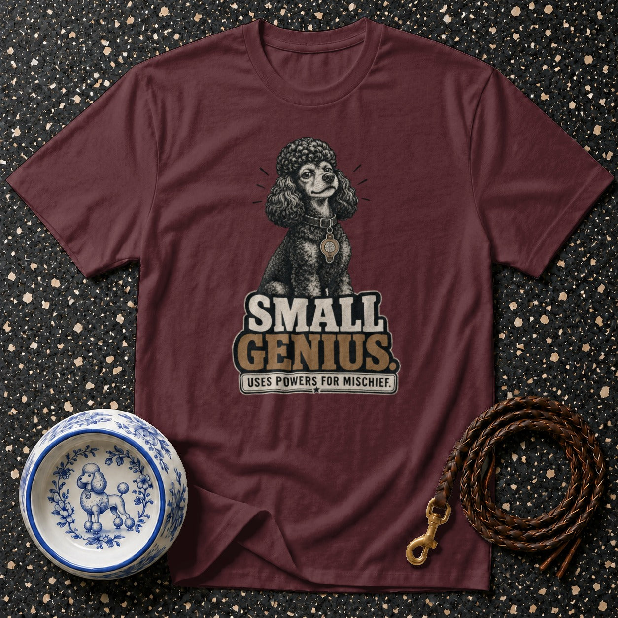Maroon t-shirt with poodle graphic reading "SMALL GENIUS. USES POWERS FOR MISCHIEF."