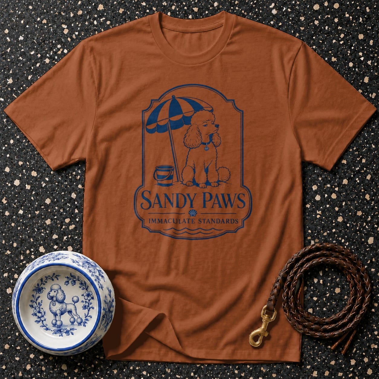 Brown t-shirt with blue "Sandy Paws Immaculate Standards" poodle beach graphic.