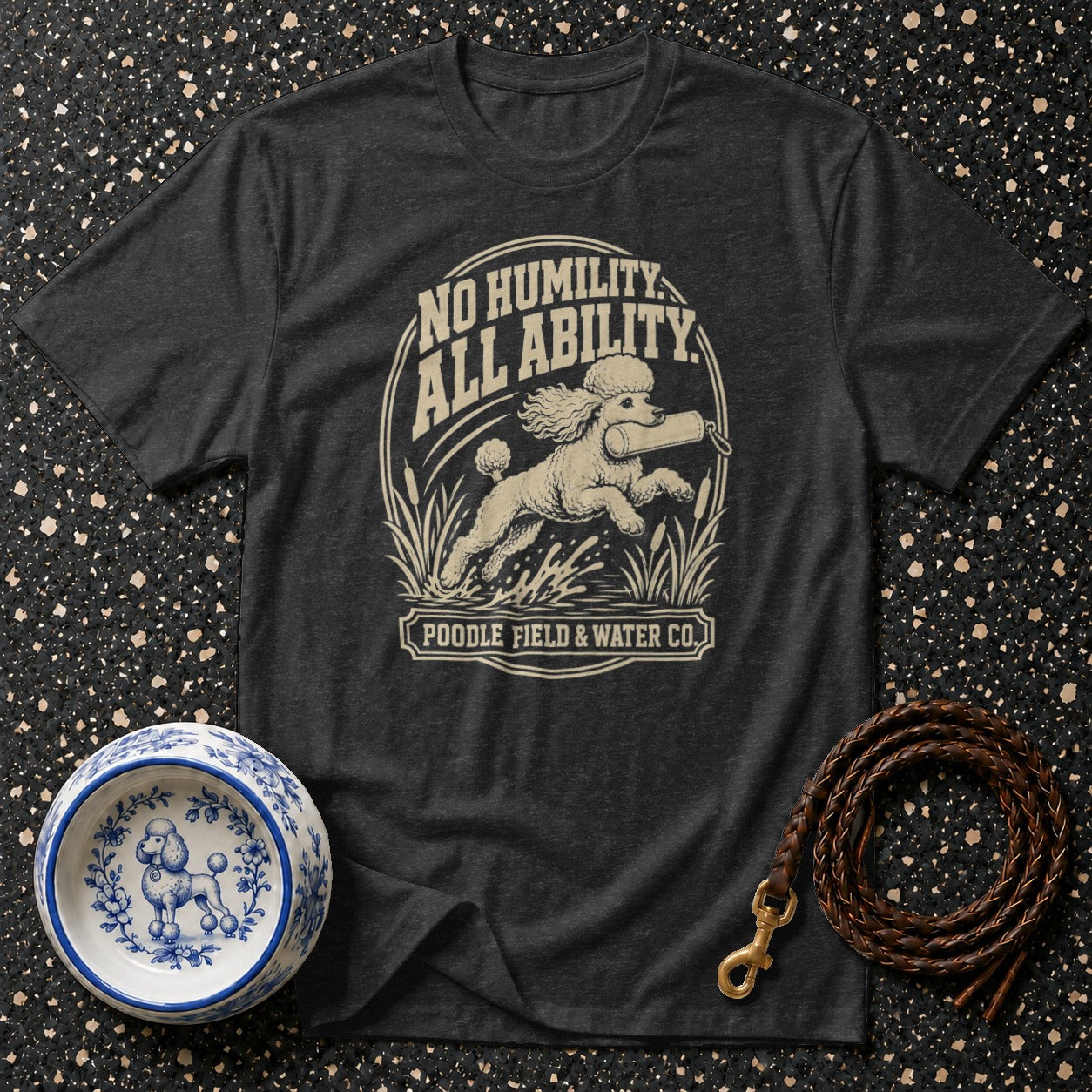 Dark grey t-shirt with a poodle retrieving a dummy, text "NO HUMILITY ALL ABILITY" and "POODLE FIELD & WATER CO."