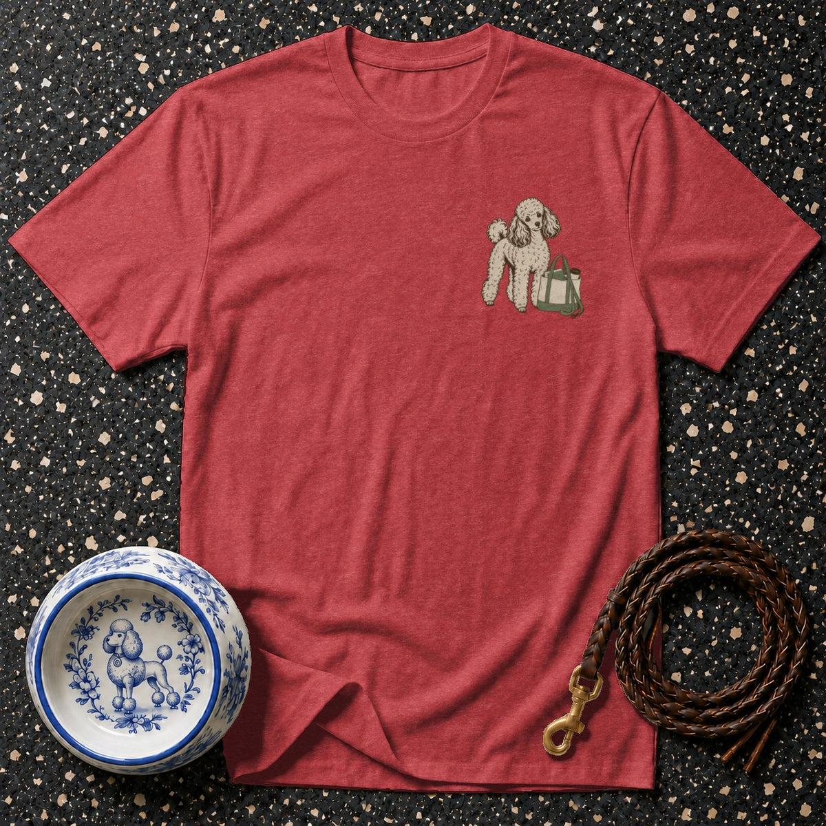 Red t-shirt with a poodle and bag graphic, a dog bowl, and a leather leash.