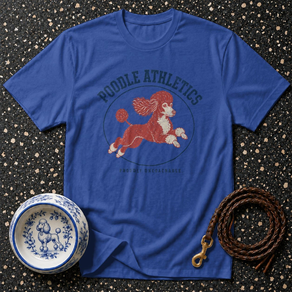 Blue t-shirt with running red poodle graphic and text "Poodle Athletics Proudly Uncoachable."