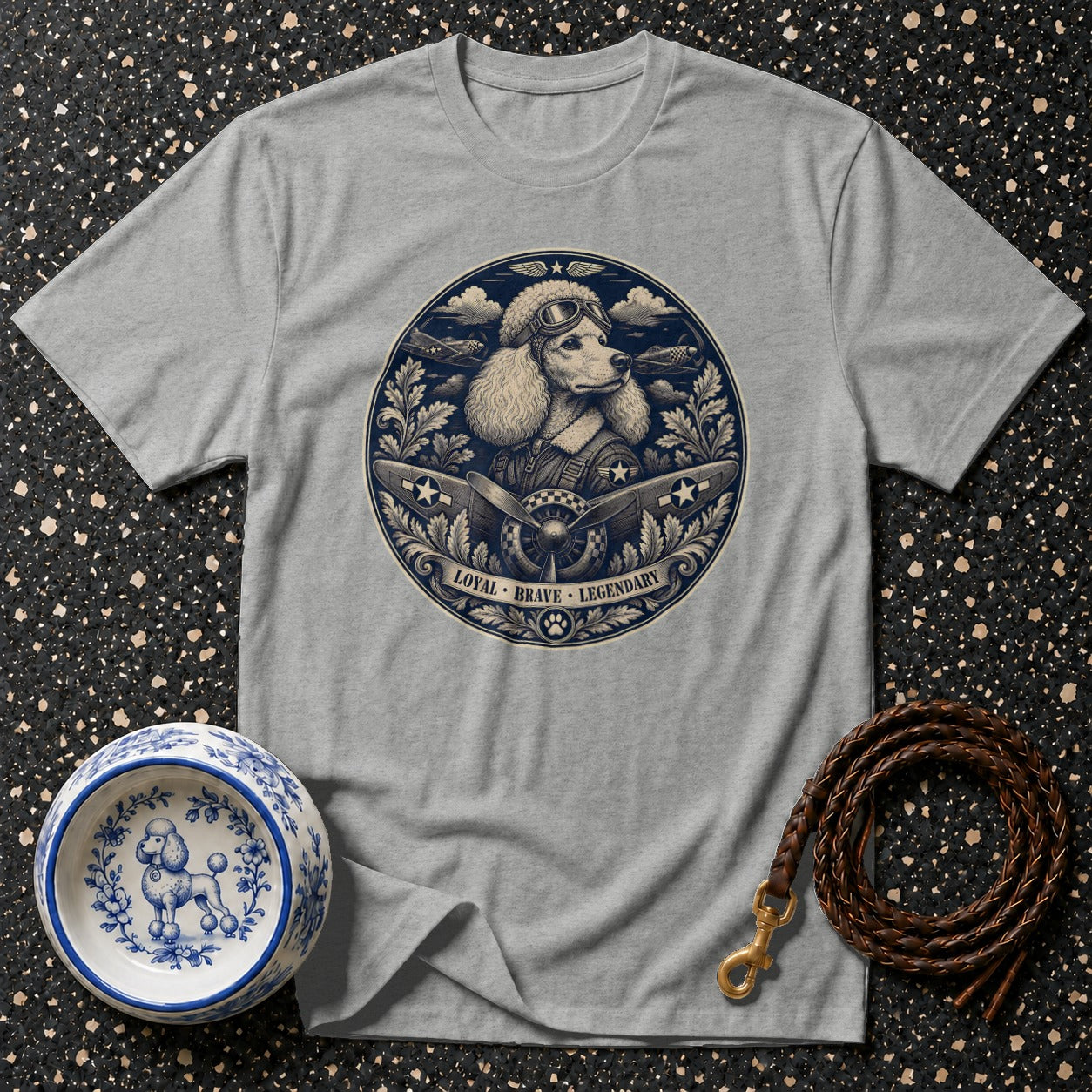 Grey t-shirt featuring a circular graphic of a poodle in aviator gear with airplanes and text: LOYAL BRAVE LEGENDARY.